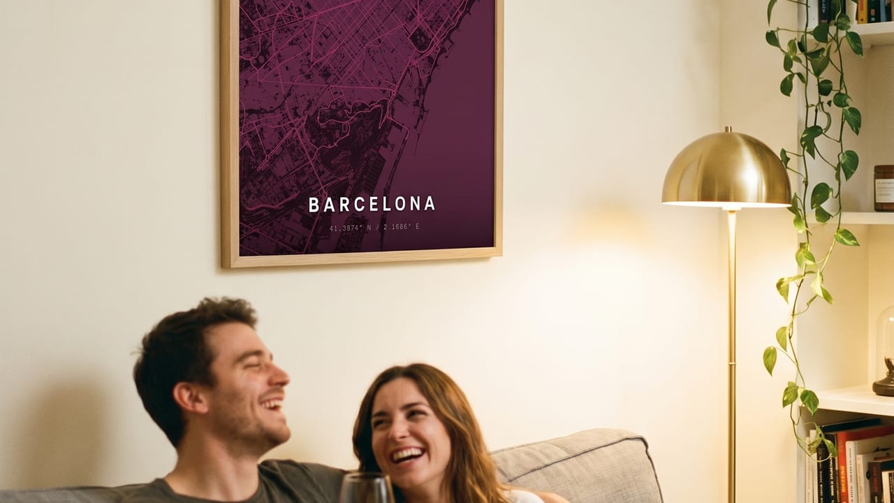 Paar mit Rotwein auf dem Sofa unter einem gerahmten Barcelona-Kartenposter